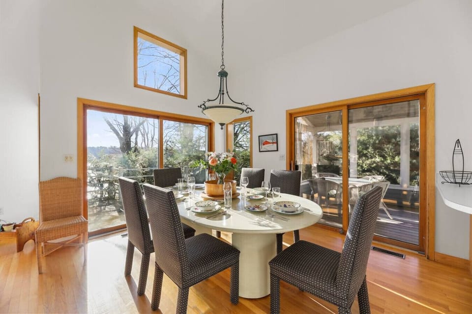 Bright dining area for six with large windows with views flowing into the outdoor patio.