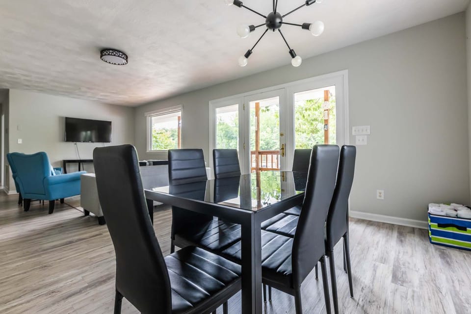 Modern dining space with a sleek table and seating for six, overlooking the outdoors