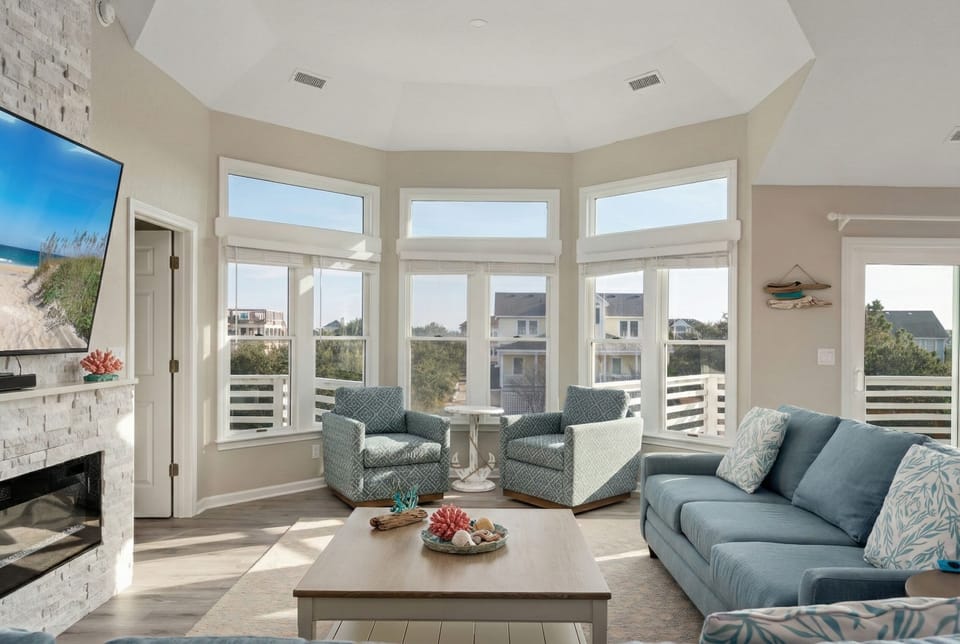 Sun-filled sitting area with plush chairs and stunning views of the surrounding neighborhood.