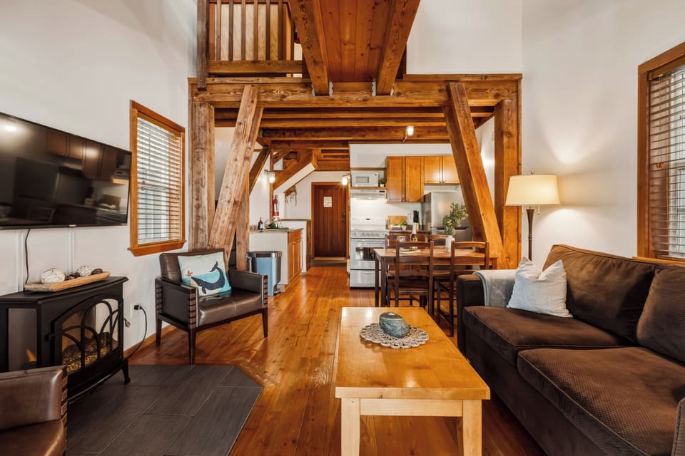 Cozy cabin featuring a sleeping loft, warm electric fireplace, and full kitchen