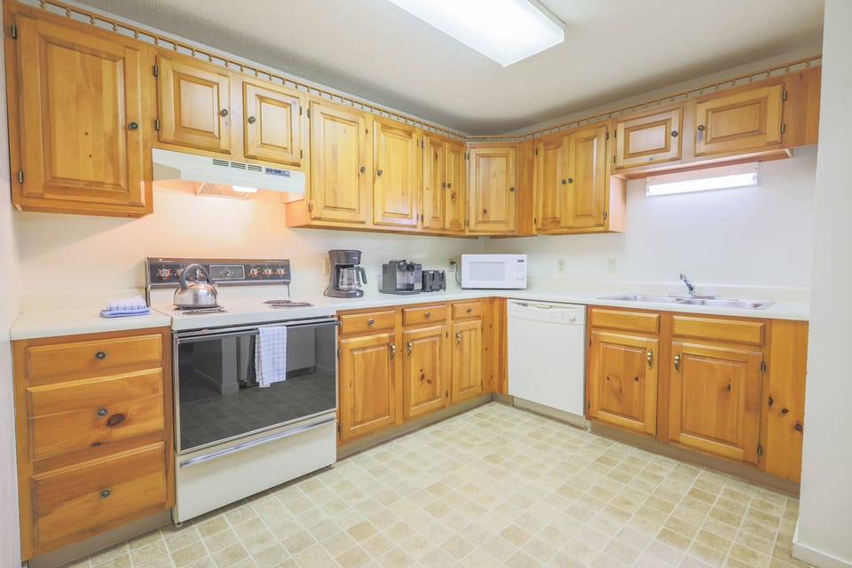 Kitchen with full size appliances, dishware, flatware, glassware, cooking pots & pans and utensils.