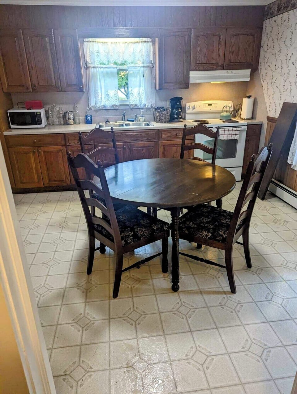  Functional kitchen with dining table, modern appliances, and charming decor.