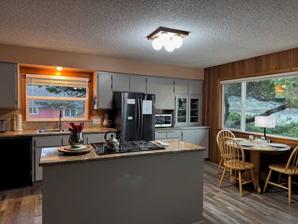 Open concert kitchen area.  Ocean view dining table next to it.