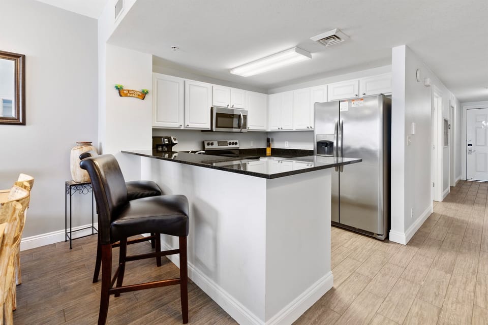 Your modern kitchen awaits with gleaming granite counters, stainless appliances, and a breakfast bar perfect for morning coffee or casual meals.