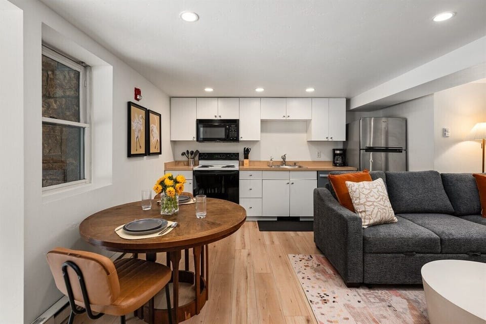 Your open-concept living/dining/kitchen area with Smart TV, full-sized fold out couch, and wood-burning fireplace.