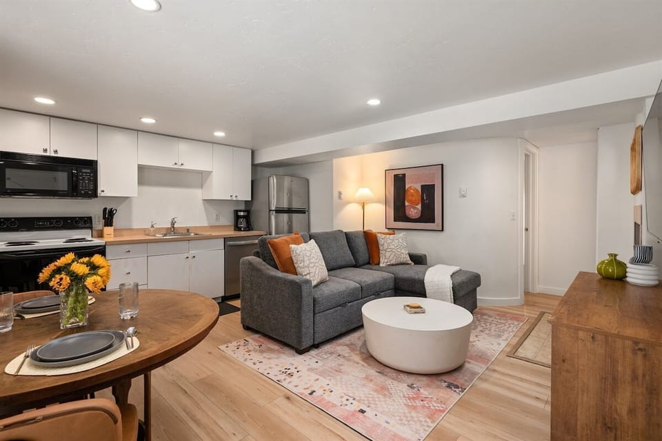Your open-concept living/dining/kitchen area with Smart TV, full-sized fold out couch, and wood-burning fireplace.