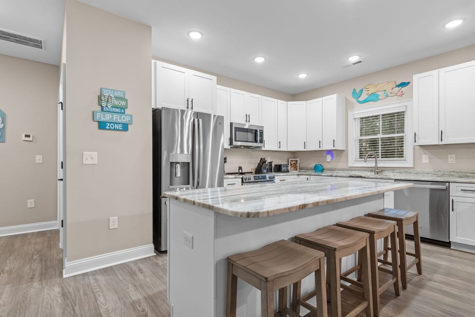 Your spacious kitchen features granite countertops, stainless steel appliances, and a breakfast bar perfect for morning coffee or casual dining together.