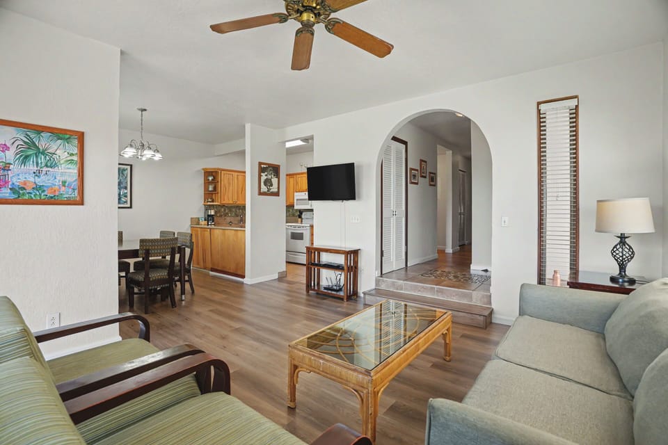 Relax in your spacious living area with comfortable seating, a mounted TV, and ceiling fan to keep you cool. The open layout connects seamlessly to the dining nook and fully equipped kitchen for your convenience.