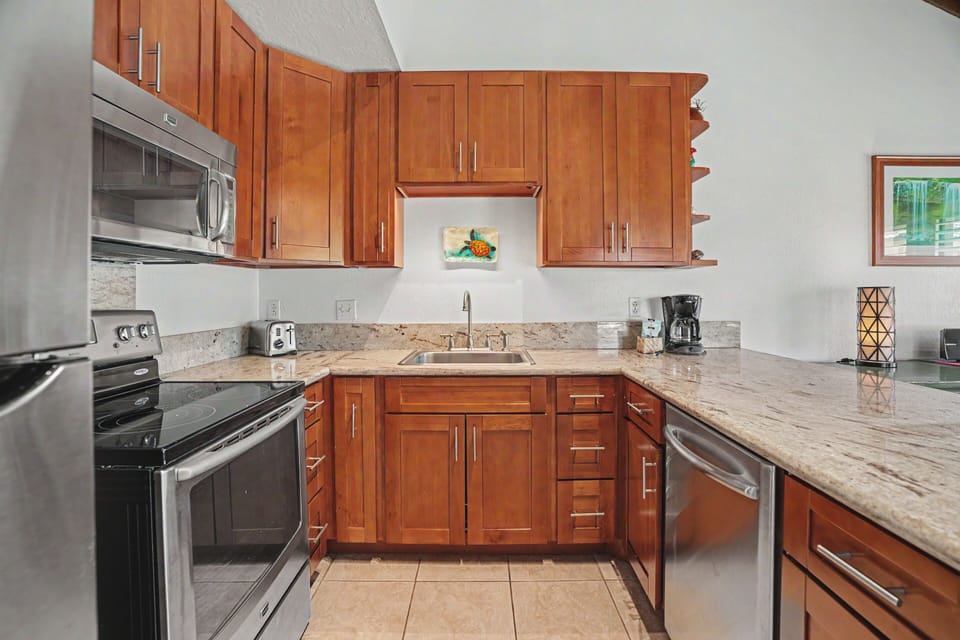 Your fully-equipped kitchen with stainless-steel appliances, granite counters, and warm wood cabinetry—perfect for preparing home-cooked meals in style.