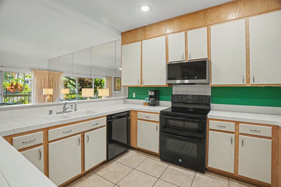 Your fully equipped kitchen features a stove, oven, microwave, and dishwasher—everything you need to whip up meals or snacks during your stay, with a garden view to enjoy.