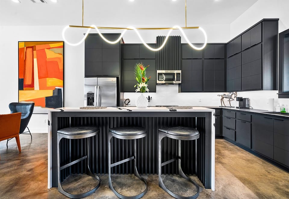 Striking gold pendant lights and clean, modern lines give this kitchen a luxurious edge, while the open layout makes it perfect for hosting or cooking up your favorite meals.