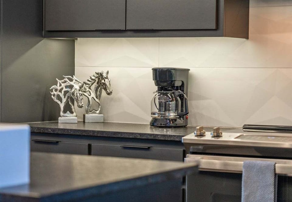 Start your mornings at this elegant coffee station, where sleek modern design and a touch of gold add a bit of luxury to your daily routine.