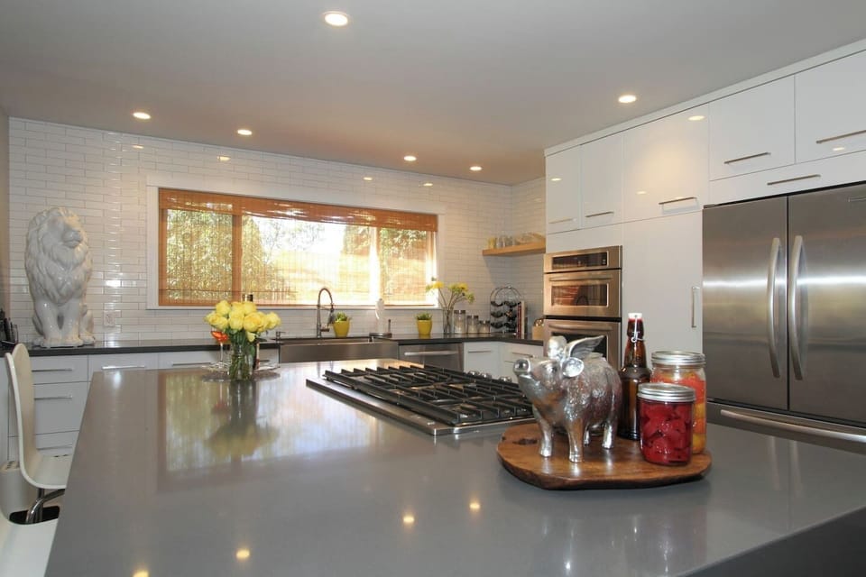 Whip up gourmet meals in this stunning chef's kitchen with a spacious island, gas cooktop, and stainless appliances. Sleek white cabinetry and quartz counters add modern elegance. Bright, expansive, and made for cooking and entertaining in style!