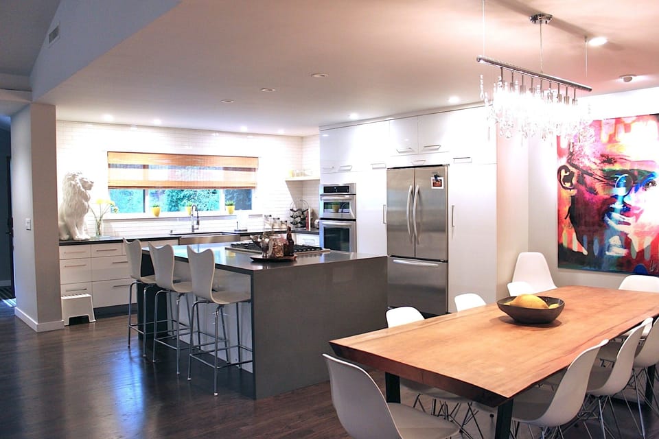 Cook and gather in this sleek, modern kitchen featuring stainless appliances, a spacious island, and bar seating. The open layout flows into a stylish dining area, perfect for entertaining. 