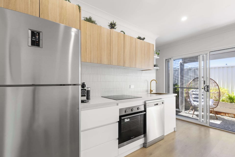 Modern, fully equipped kitchen 🍳 with stovetop, fridge 🧊, dishwasher 🍽️, and all cookware—perfect for preparing meals with ease.