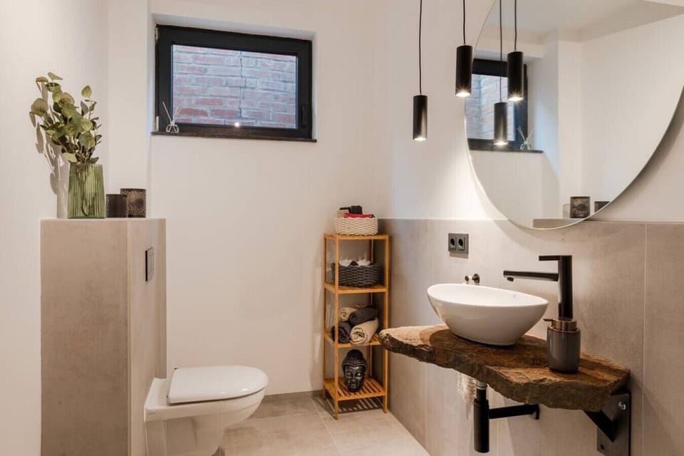 Modernes Badezimmer mit großzügiger Walk-in-Dusche, stilvollem Naturstein-Waschtisch