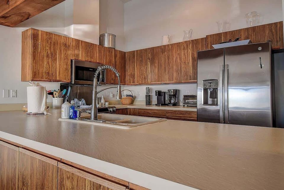 Whip up your favorite meals in this fully equipped kitchen featuring sleek countertops, a spacious refrigerator, and everything you need to channel your inner chef  #KitchenGoals #