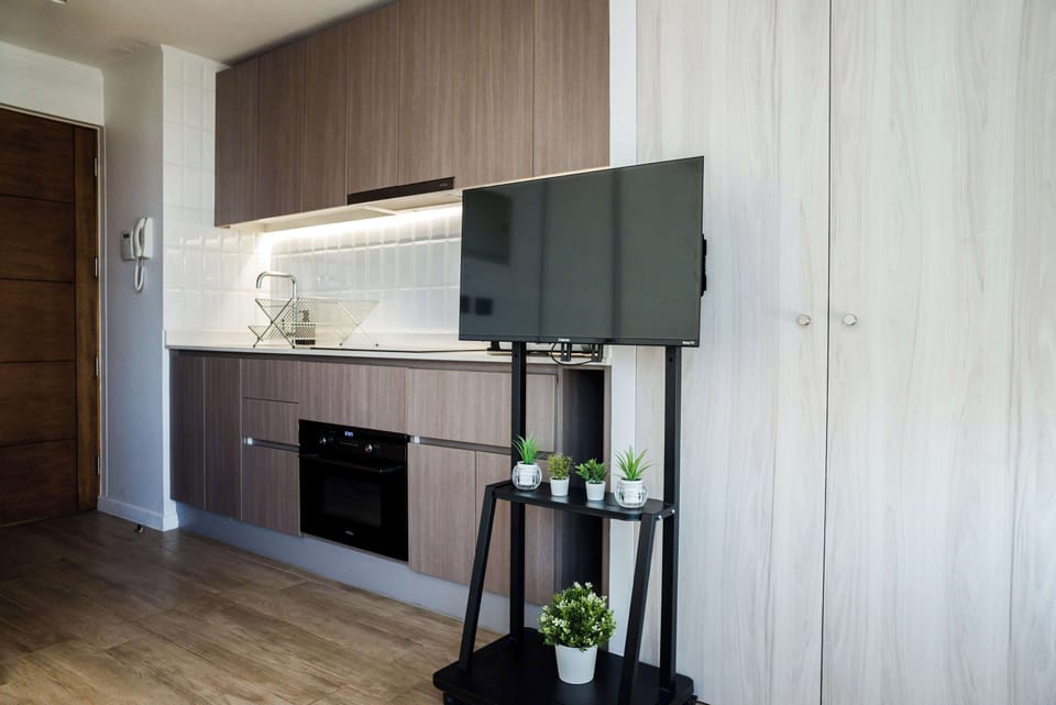 Modern kitchen with sleek cabinetry and TV setup, ideal for cozy cooking and entertainment.