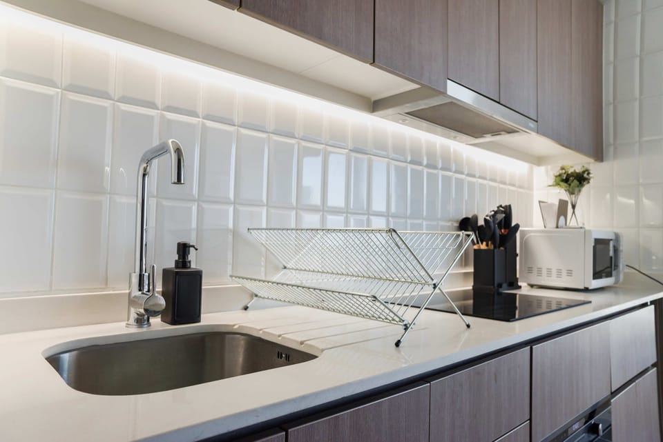 Modern kitchen with sleek finishes, under-cabinet lighting, and essential appliances for a seamless cooking experience.