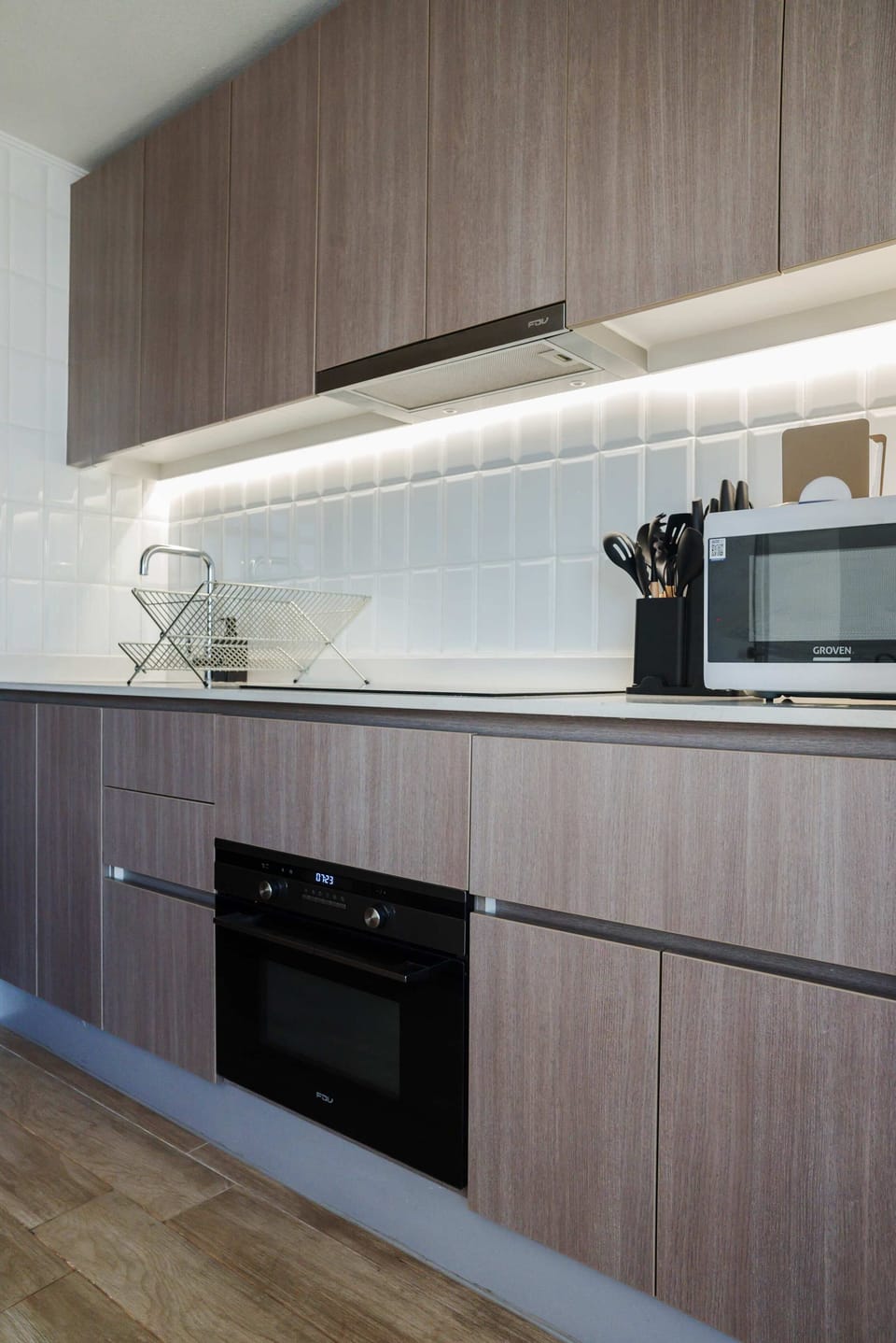 Modern kitchen with stylish cabinetry and ambient lighting, perfect for cozy cooking sessions.
