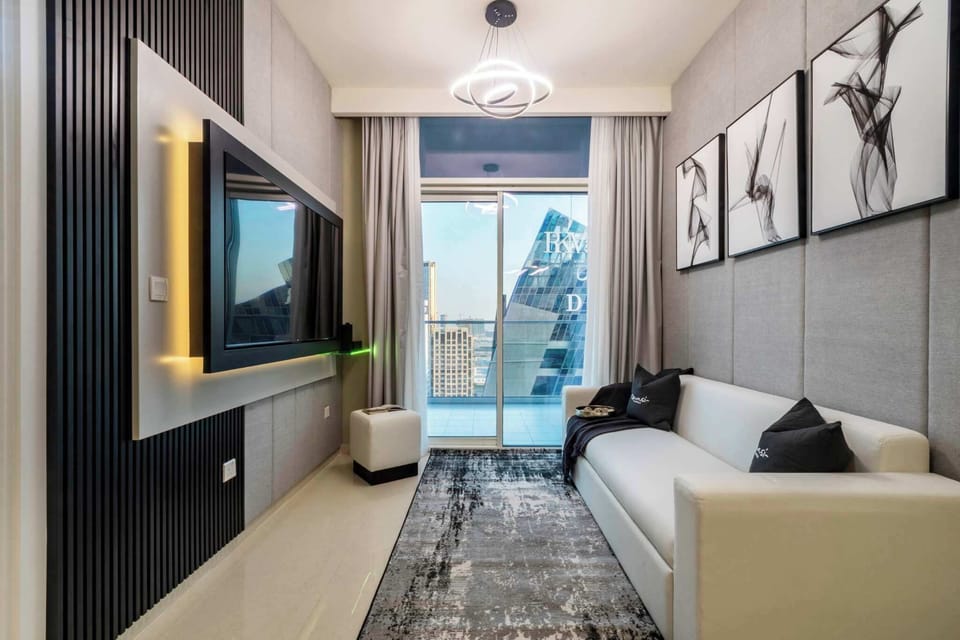 This stylish living room in Business Bay, Dubai offers city views, modern black paneling and art. Near Burj Khalifa and DIFC, it’s perfect for relaxing on the sofa or enjoying the balcony skyline.