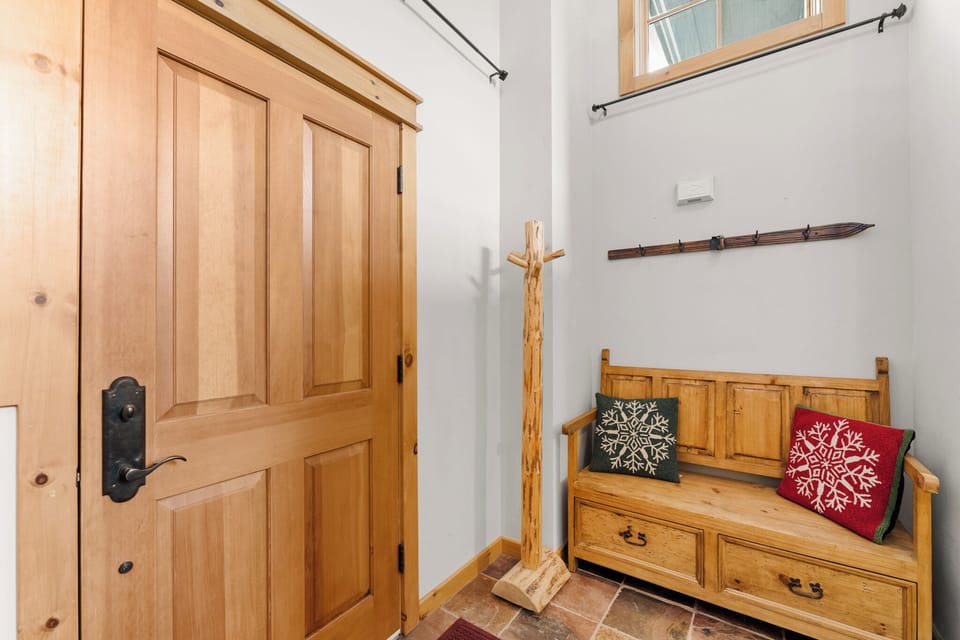 Your cozy entryway welcomes you with warm wood and festive touches, creating the perfect mountain retreat atmosphere.