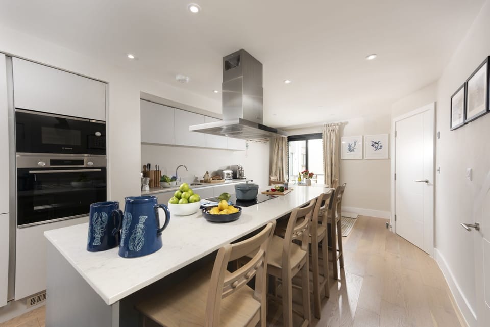 Breakfast bar with a built-in wine fridge and 4 barstools - Harlyn Folly