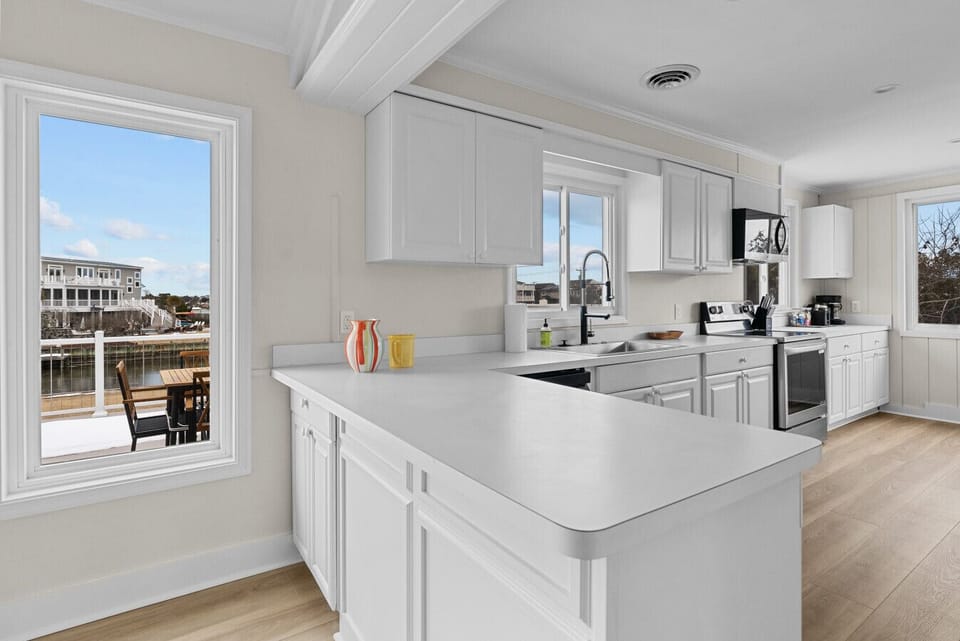 Bright, fully equipped kitchen with spacious counters, modern appliances, and a window view, perfect for cooking and serving the whole crew.