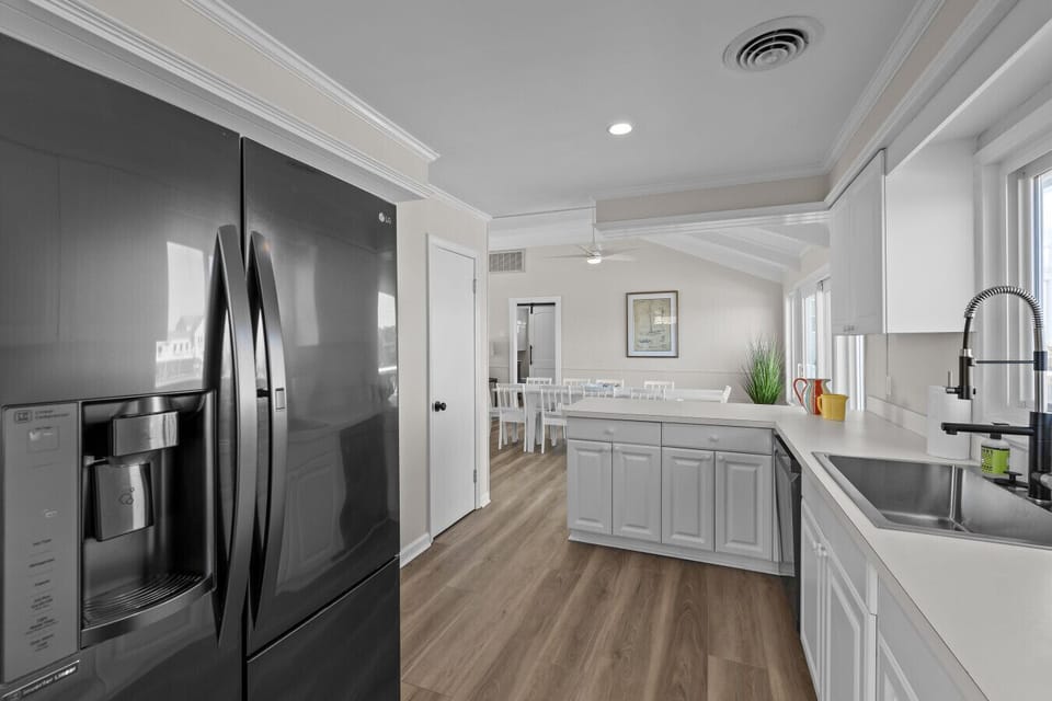 Spacious, updated kitchen with stainless fridge, large island, and plenty of counter space, open to the dining area for easy entertaining.
