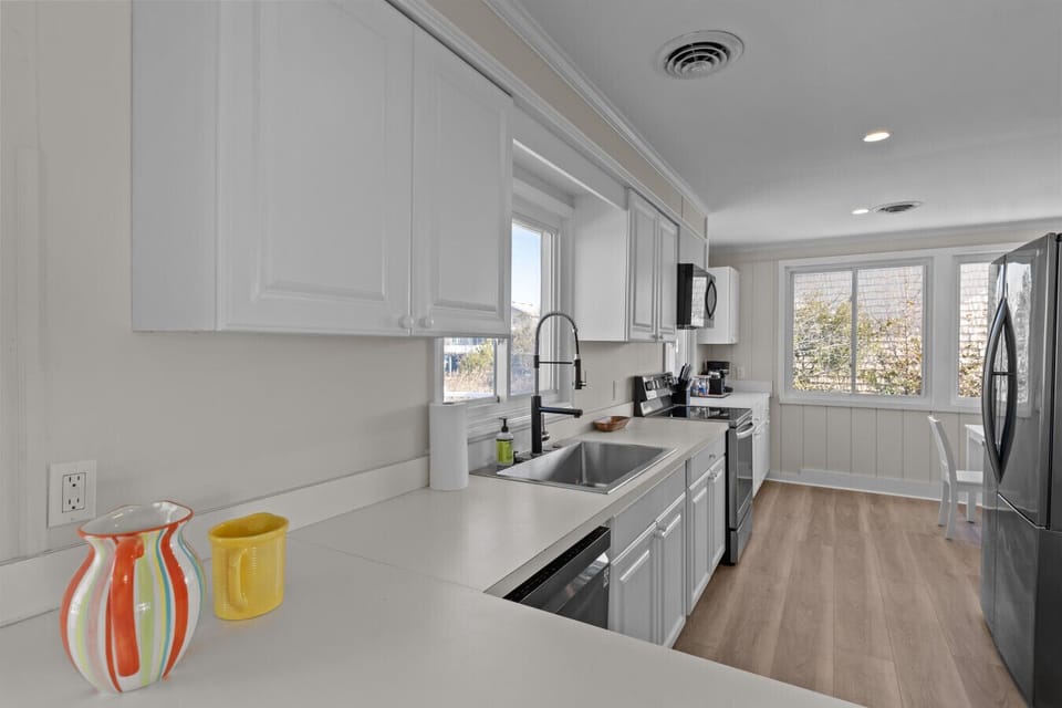 Modern galley kitchen with white cabinetry, stainless appliances, and plenty of prep space; bright, clean, and ready for family meals.