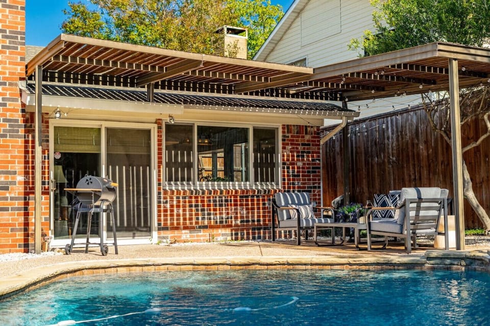 A patio with a BBQ by the pool