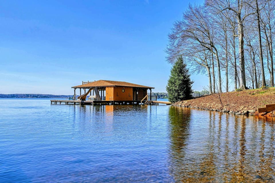 Lakefront boathouse with a water slide, kayak, and easy access to fun activities on the water.