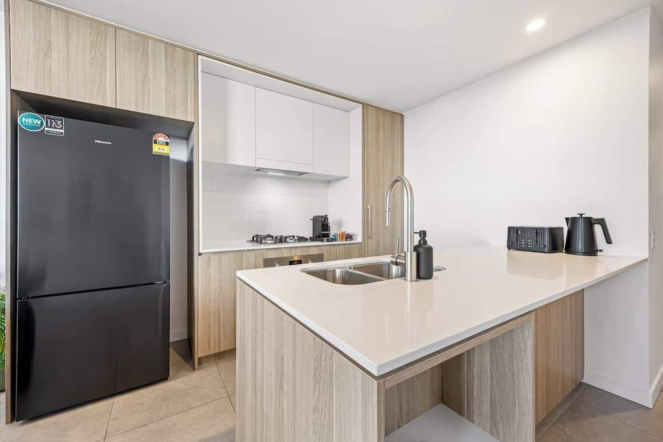 Clean, modern kitchen with an island bench, quality appliances, and ample storage. Designed for easy cooking and everyday use, providing a functional space to prepare meals comfortably during your stay.
