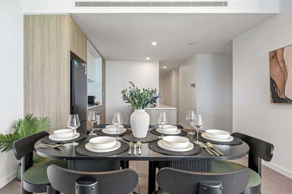 Stylish dining area with a generously set table and modern finishes. A comfortable space for shared meals and gatherings, with an open layout that connects easily to the living and kitchen areas.
