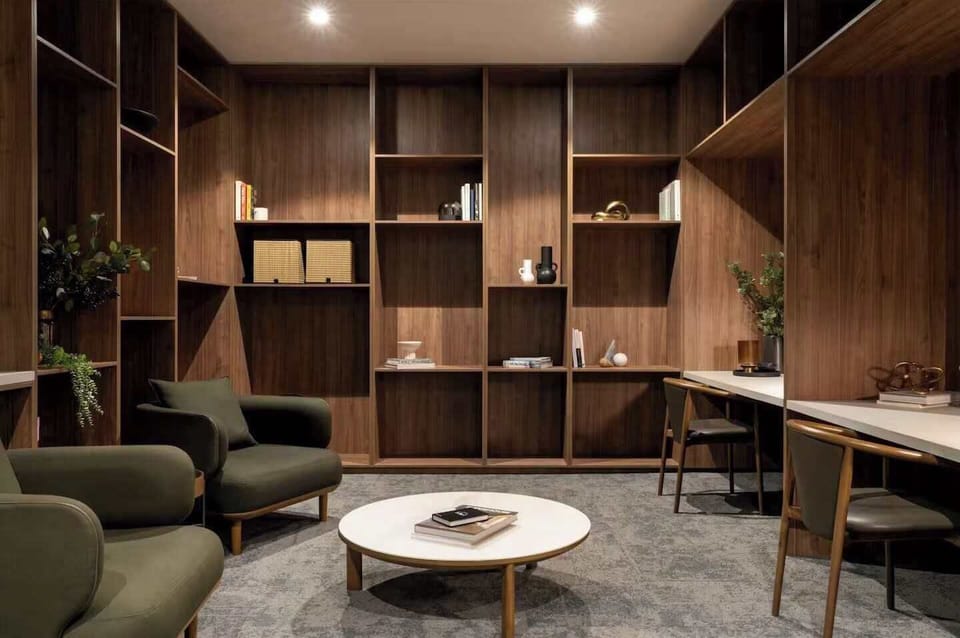 Shared residents lounge with comfortable seating, work desks, and warm timber finishes. A quiet, well designed space to read, work remotely, or relax outside the apartment in a calm setting.
