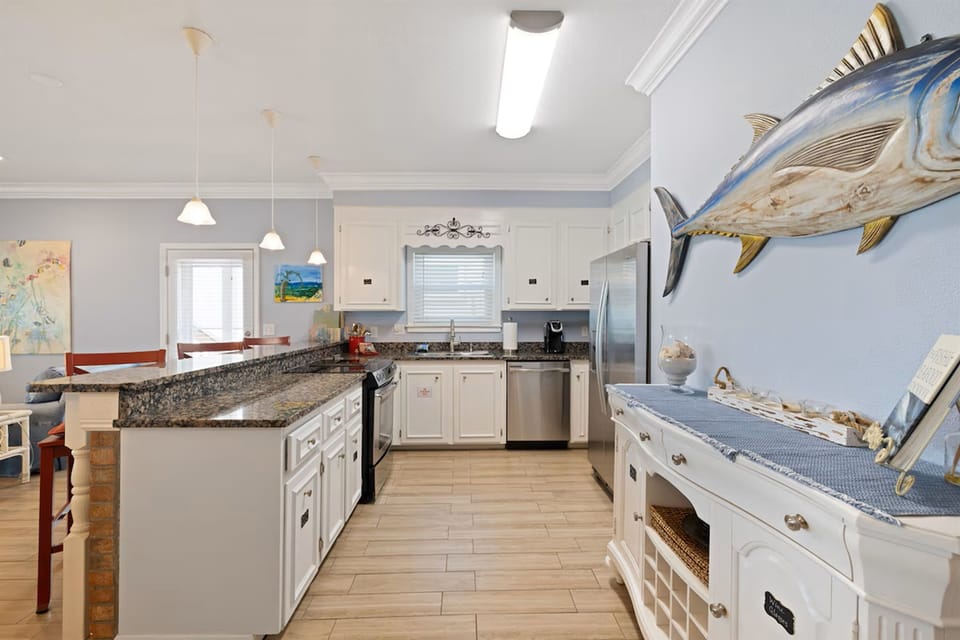 Cook with coastal charm in this spacious kitchen where granite counters and nautical touches create your perfect beachside retreat.