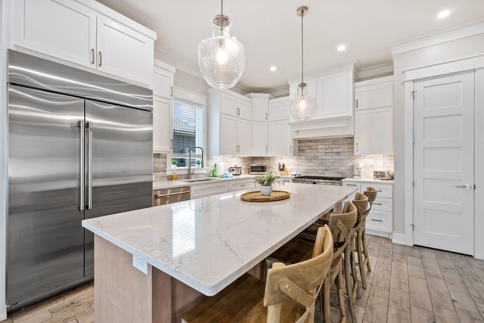 Your gourmet kitchen awaits with gleaming marble counters, professional appliances, and elegant pendant lighting for memorable meals.