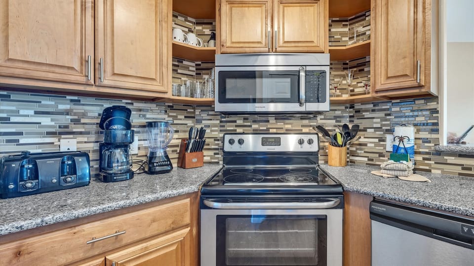 Beautiful backsplshe frames the microwave and stove/oven.