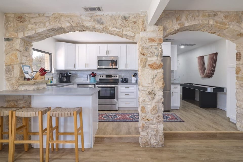 Warm stone archways, bright open spaces, and modern finishes create a home that feels both elevated and inviting. From casual breakfasts at the island to late-night games nearby, every space flows effortlessly together.