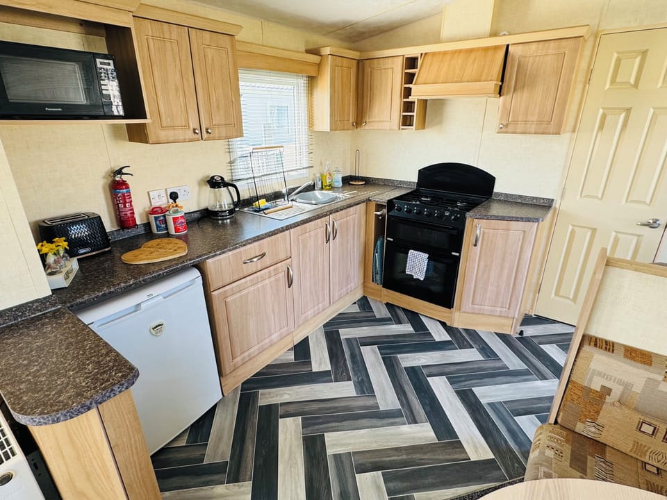 Modern kitchen with oven, microwave, fridge & essentials—perfect for self-catering stays in Skegness.