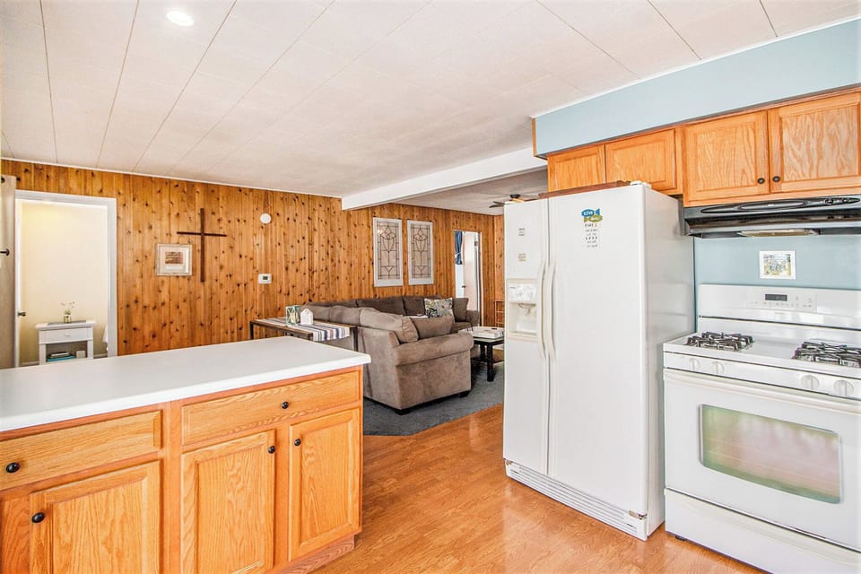 Kitchen with gas range and full-size fridge, open to the living room