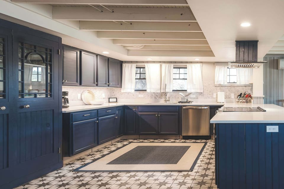 Chef's kitchen with navy cabinetry and stainless steel appliances