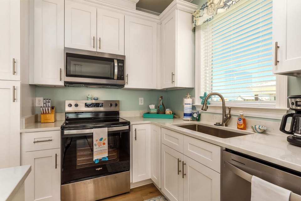 Your bright, fully-equipped kitchen awaits with modern appliances and cheerful turquoise accents for memorable home-cooked meals.