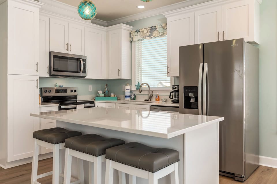 Your modern kitchen awaits with gleaming countertops, stainless steel appliances, and a breakfast bar perfect for morning coffee.