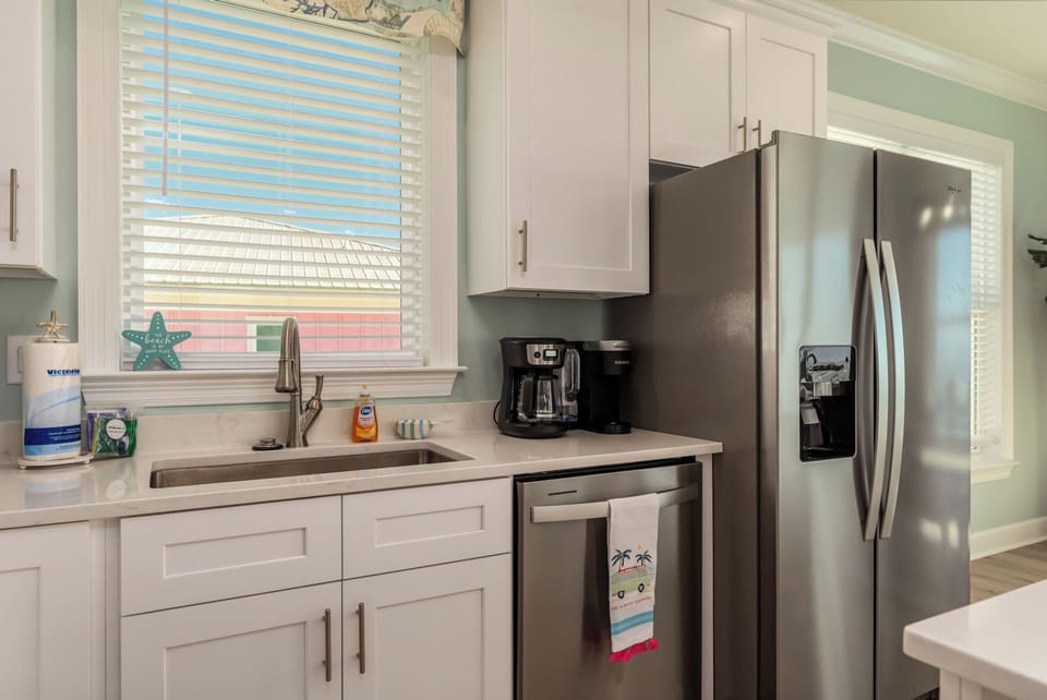 Your bright, fully-equipped kitchen awaits with modern stainless appliances and coastal charm for preparing memorable vacation meals.
