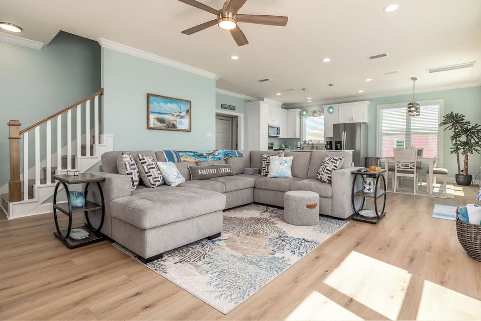 Sink into plush sectional seating where coastal blues meet modern comfort in your bright, open living space.