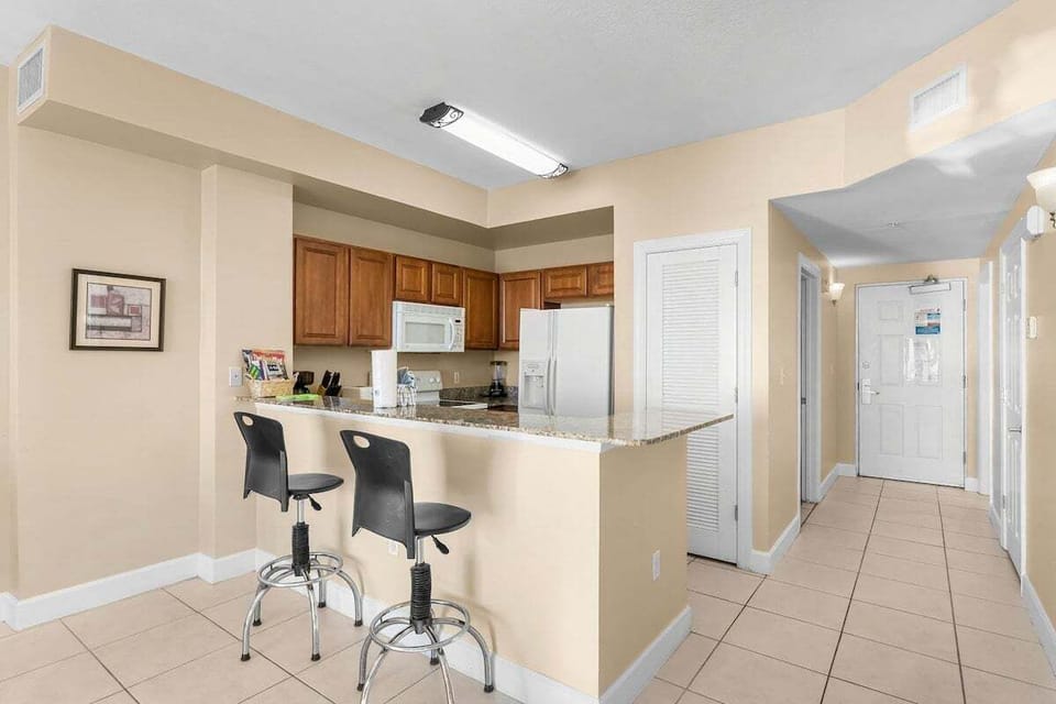 Modern kitchen with stainless steel appliances and granite countertops.