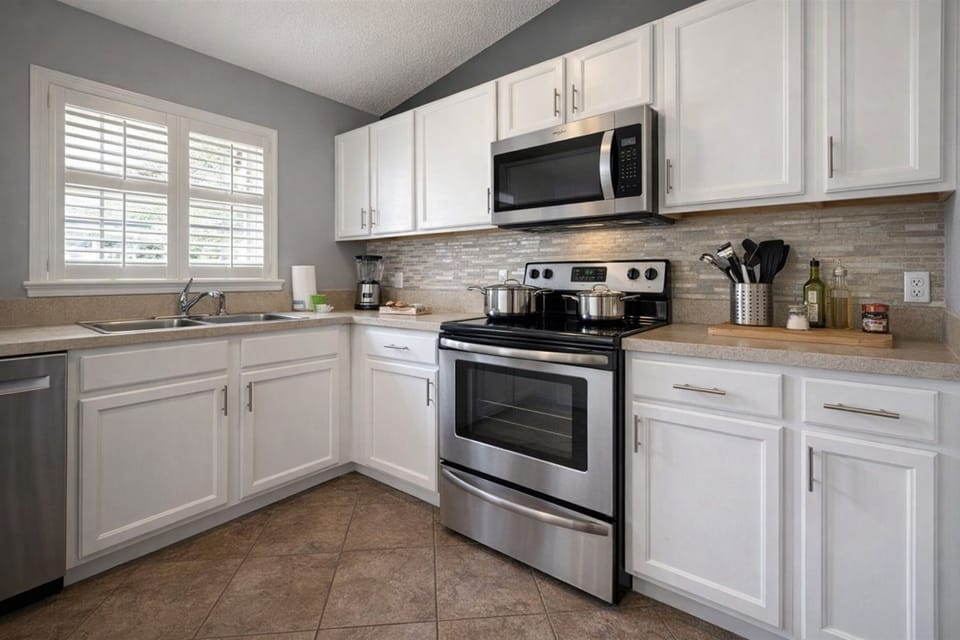 Bright fully equipped kitchen with stainless steel appliances and ample natural light