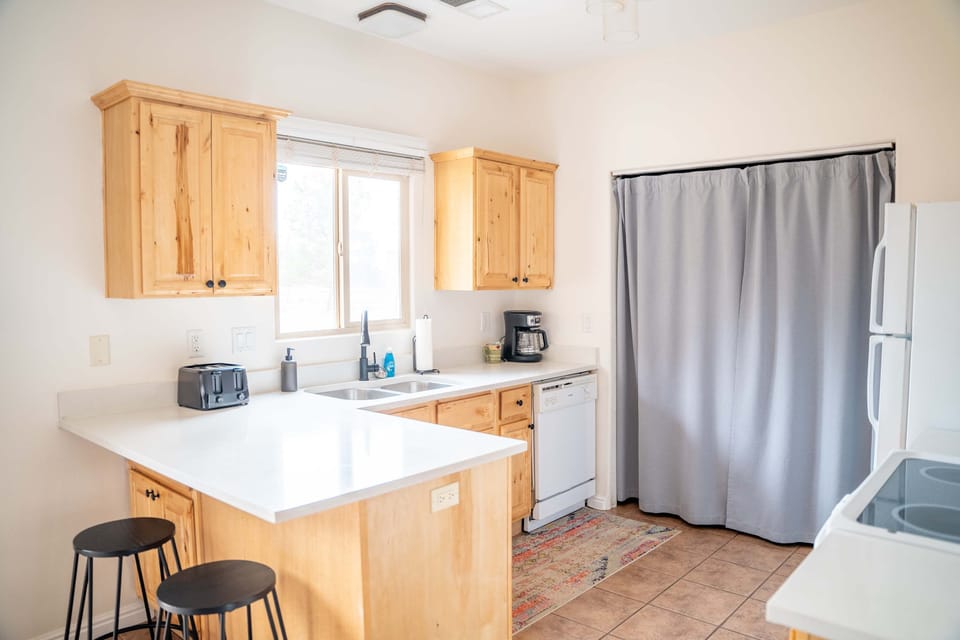 The kitchen is fully equipped with pots and pans, utensils and cutlery, oven, stove, fridge, microwave, dishwasher, crock pot, baking pans, coffee maker, toaster and more!