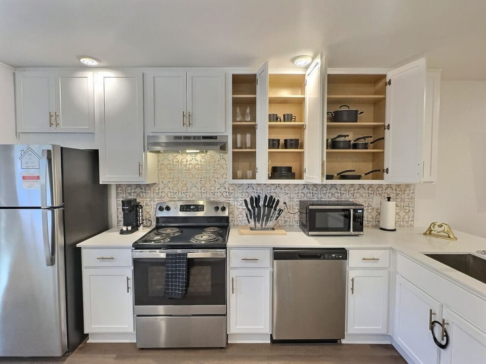 Equipped with a stainless steel oven, dishwasher, and microwave, this space ensures all your cooking needs are met effortlessly.